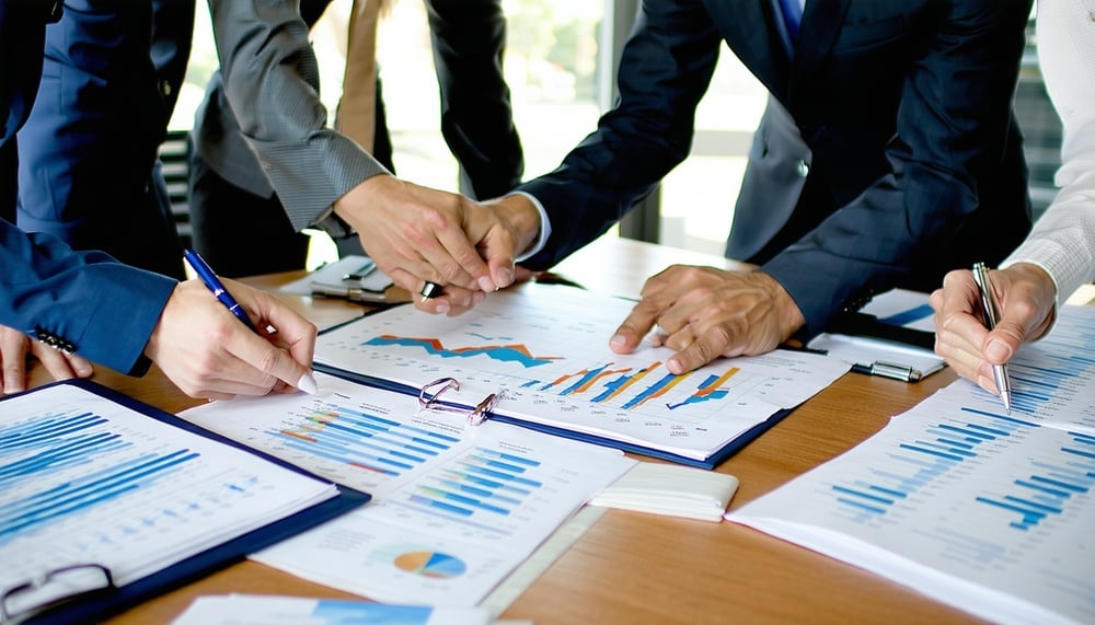 Business professionals strategizing over financial and marketing plans Business professionals strategizing over financial and marketing plans